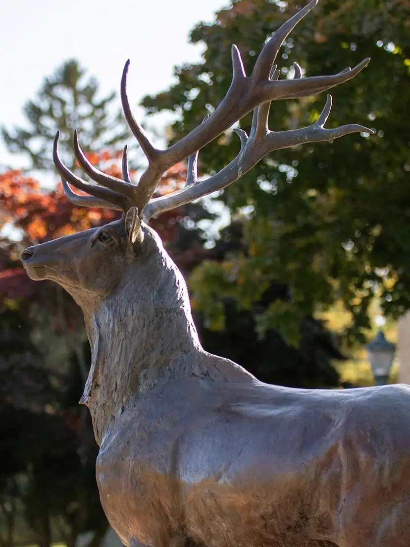 An elegant statue of a deer with impressive antlers, representing a blend of artistry and nature in its depiction.