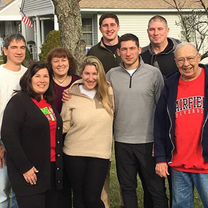 A group of people post for a photo outdoors.