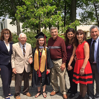 A group of people post for a photo outdoors.