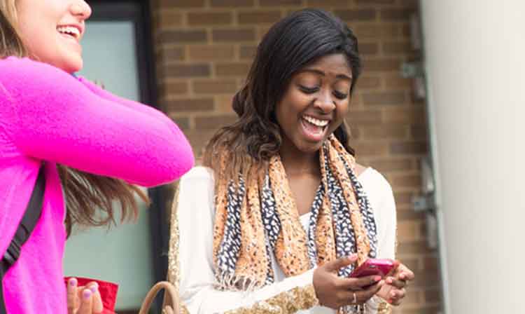 student with scarf looking at phone