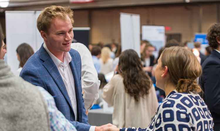 A student and employer shake hands.