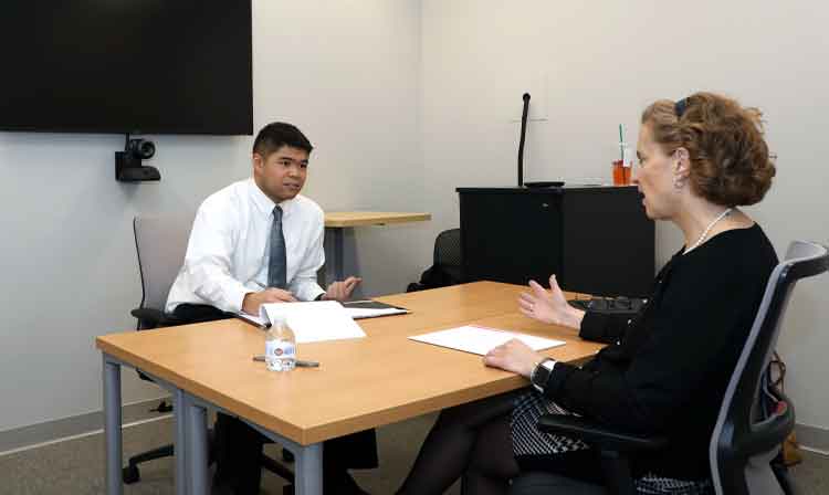 Two people sit at a table in a room