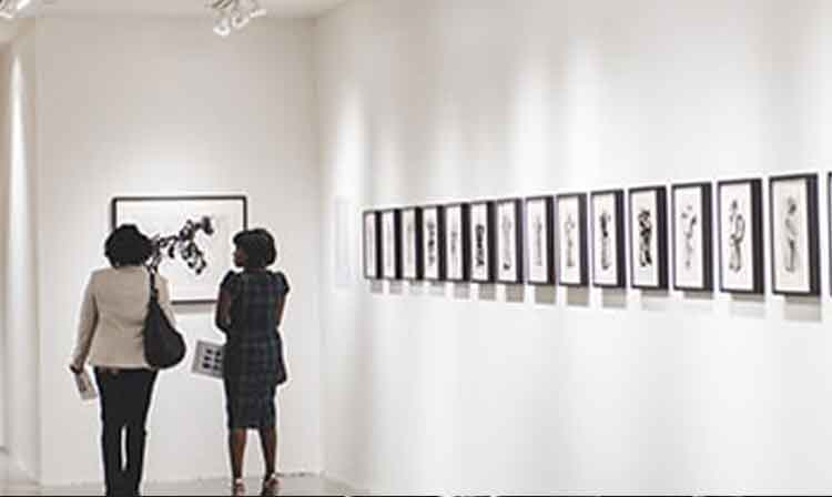 two guests look at art works in the walsh gallery.