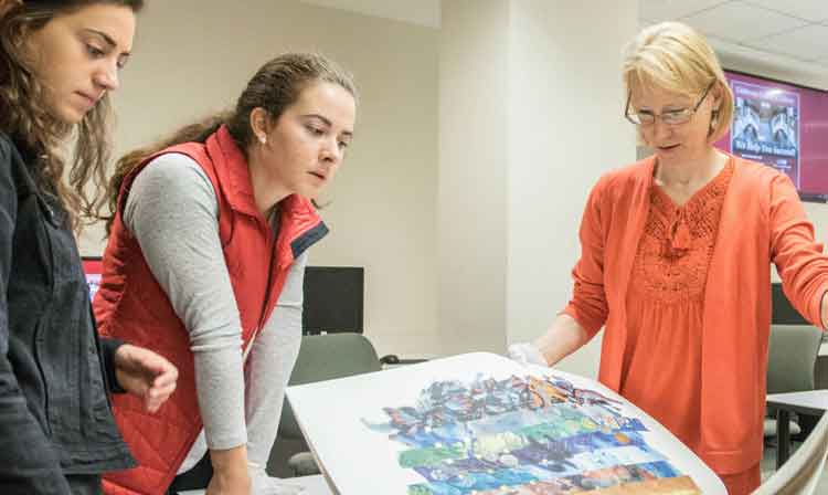 Art History and Visual Culture professor showing students an abstract painting broken up as strips of images. 