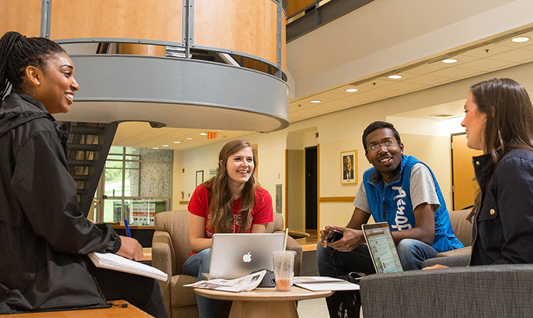 A group of students on laptops sharing a discussion.