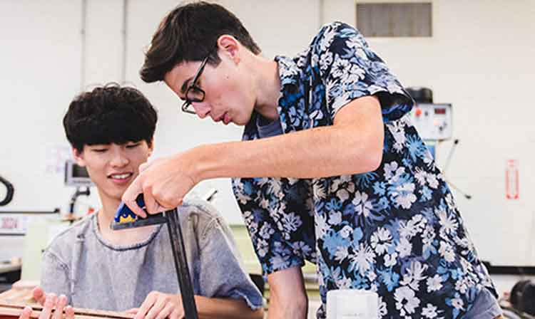 Two students working on a project in a classroom.