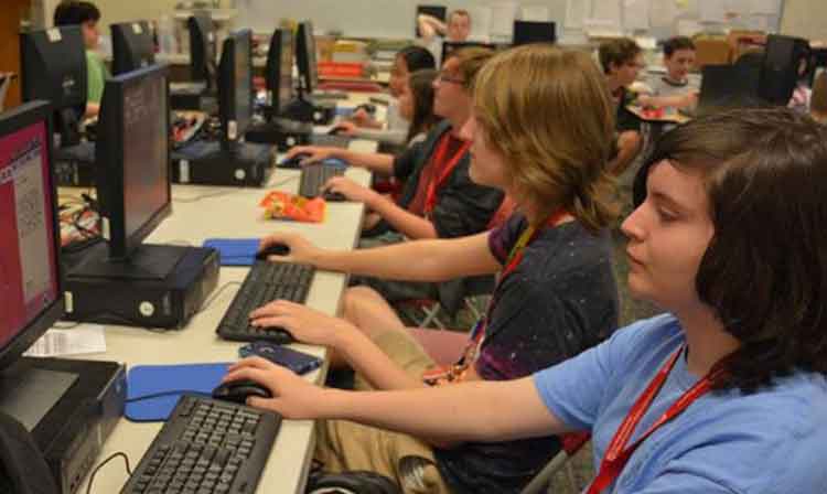 Row of young students working in a computer lab