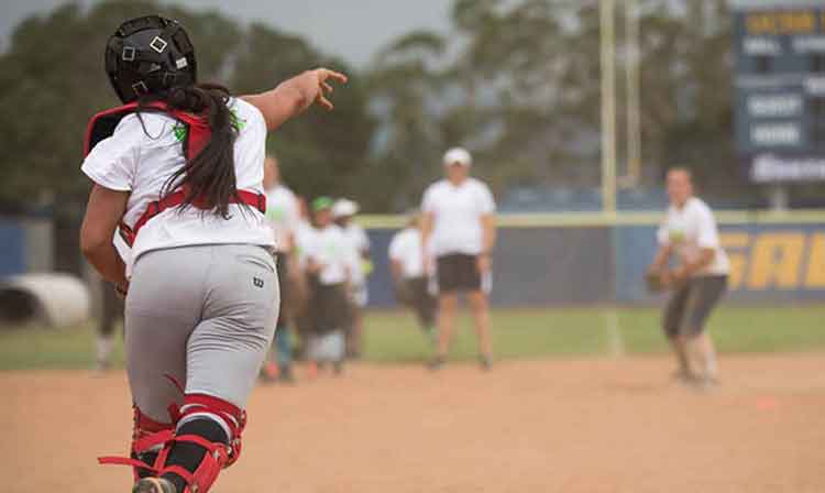 Softball catcher throws down the third base line