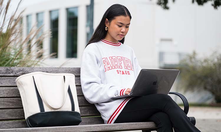 Student sitting on bench outside 