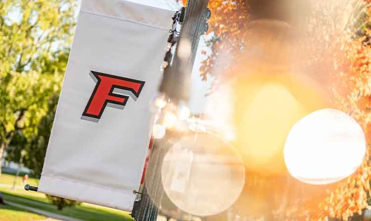 A white banner with a red F hangs off a lamp post.