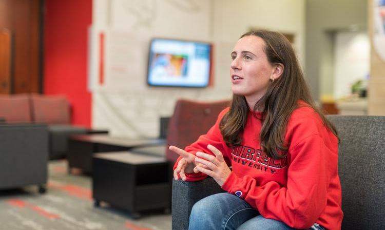 Students sitting and explaining something in the Barone campus center. 