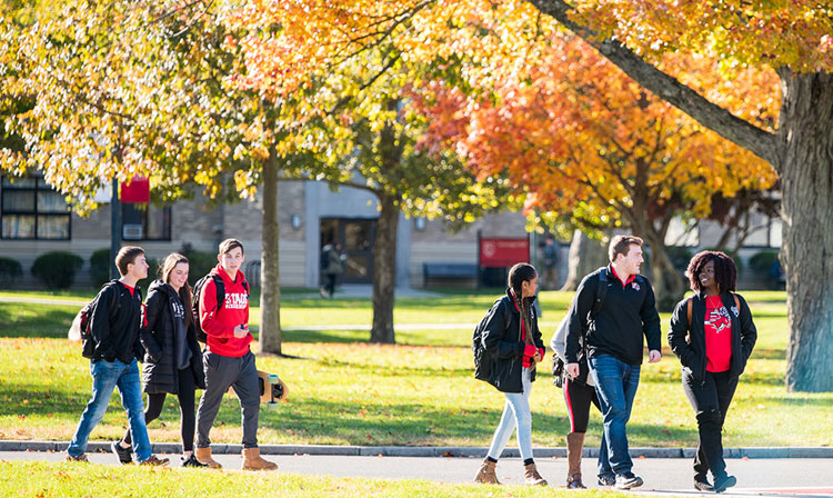 Students walking through campus on a bright fall day. 