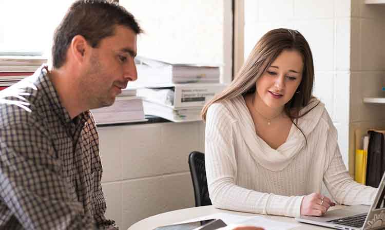 Photo of faculty member working with a student in an office.