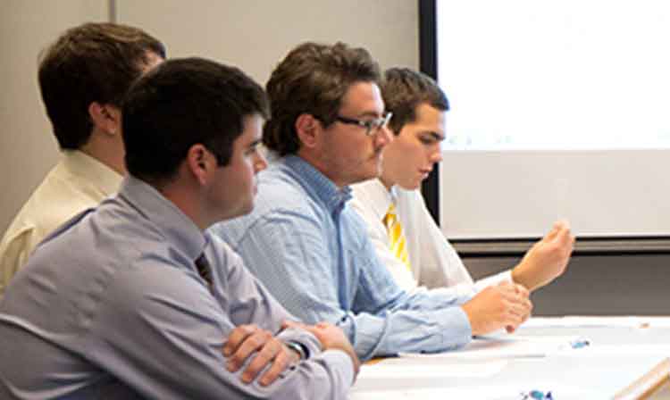 A group of students sit at a table.