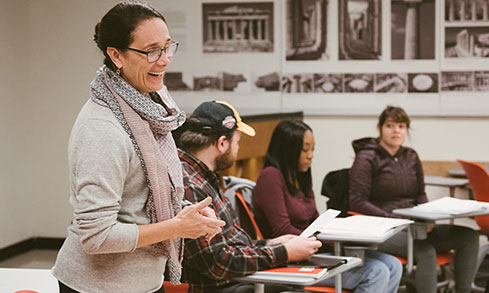 A woman teaches a classroom full of engaged students.