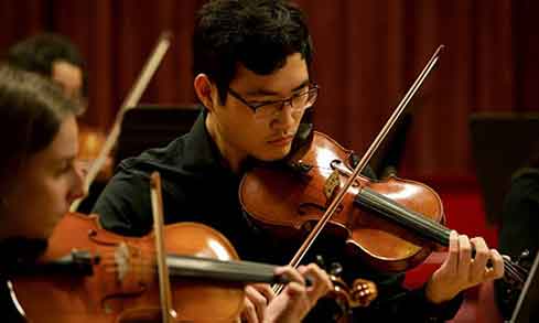 Students playing violin together.