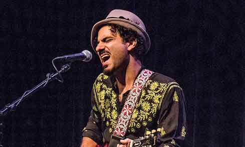 Artist playing an electric guitar performing. 