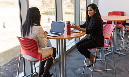 Students sitting and collaborating in a university space.