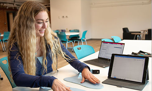 Student works with device as she puts her hands on two pads. 