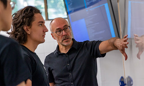 Professor giving an explanation of something on a computer screen.