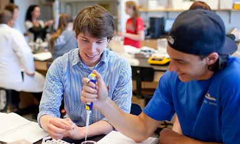 two students work at a lab table.