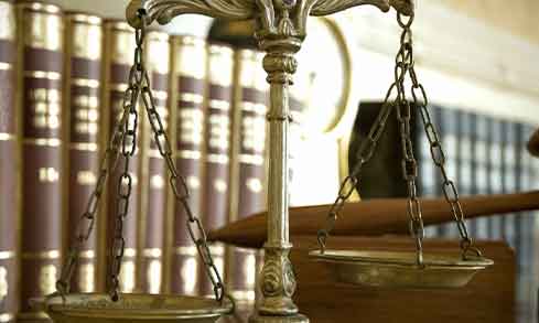 an image of scales on a desk with books in the background.