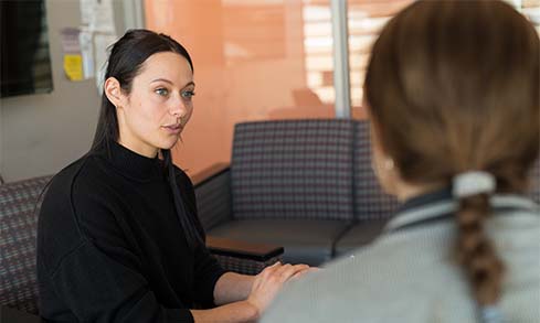 Image of student and staff member chatting