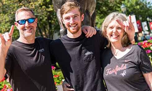 A student and his parents smile for a photo