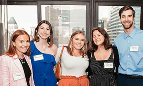 five young alumni pose for a photo