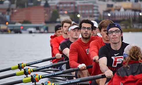 A crew boat of eight moves on the water. 