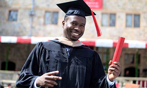 Image of a student in his cap and gown on graduation day