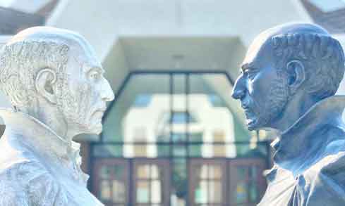 Two stone statues face each other outdoors.