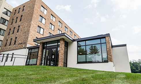 The exterior of a brick building with windows and black trim.