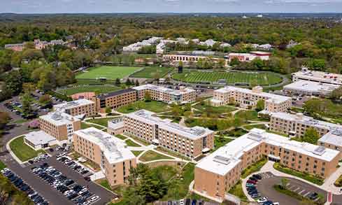 An aerial view of campus with buildings, roads, and athletic fields.