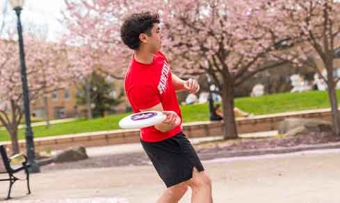 A student plays frisbee outdoors.