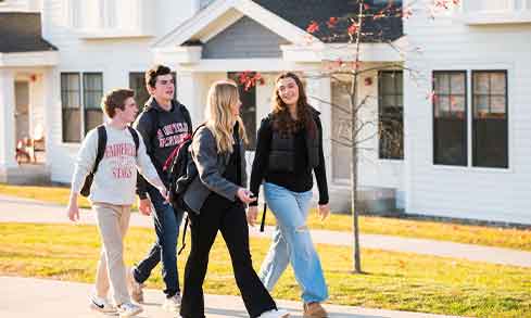 A group of students walks outside of townhouses.