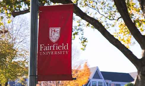 A Fairfield University banner hangs off a lamp post.