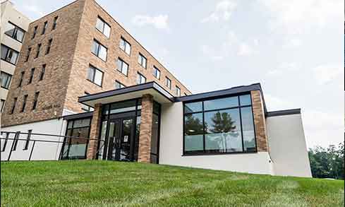 An exterior shot of a brick building with windows and a black trim.