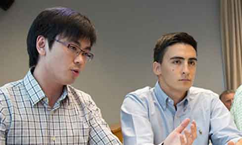 Three students sit at a table.