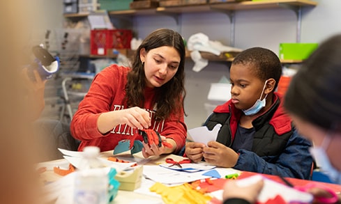 Fairfield student helping a child work on a hands-on project.