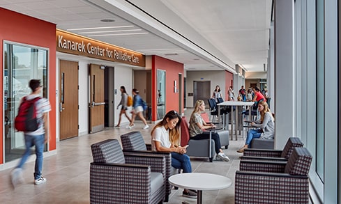 Students studying and walking through the main sitting area outside the Kanarek Center.