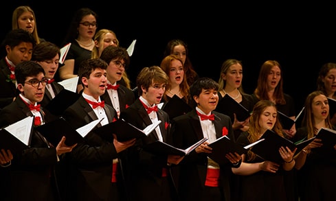 Choir students singing and performing at a concert.