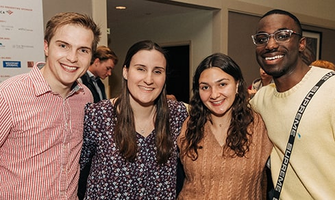 Four students smiling in a group during their attendance at the Leadership Awards.