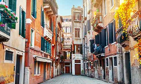 A view down an Italian street bordered by colorful houses.