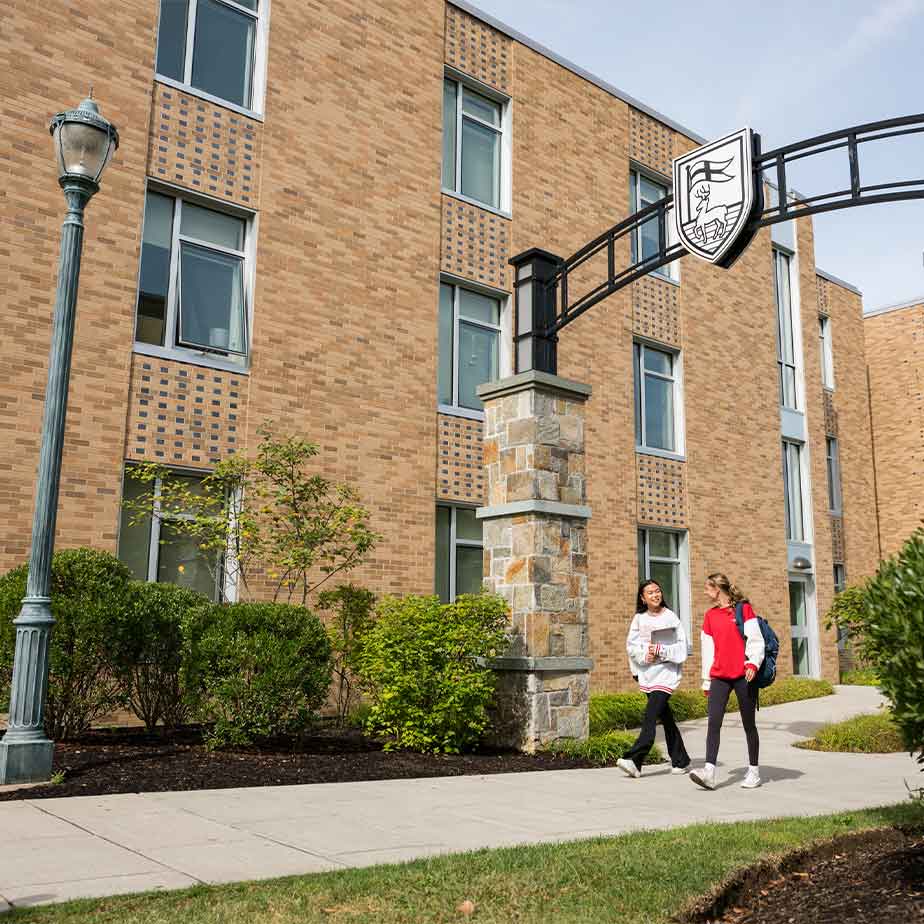 Students traverse the Fairfield University campus, engaged in conversation and enjoying their surroundings.