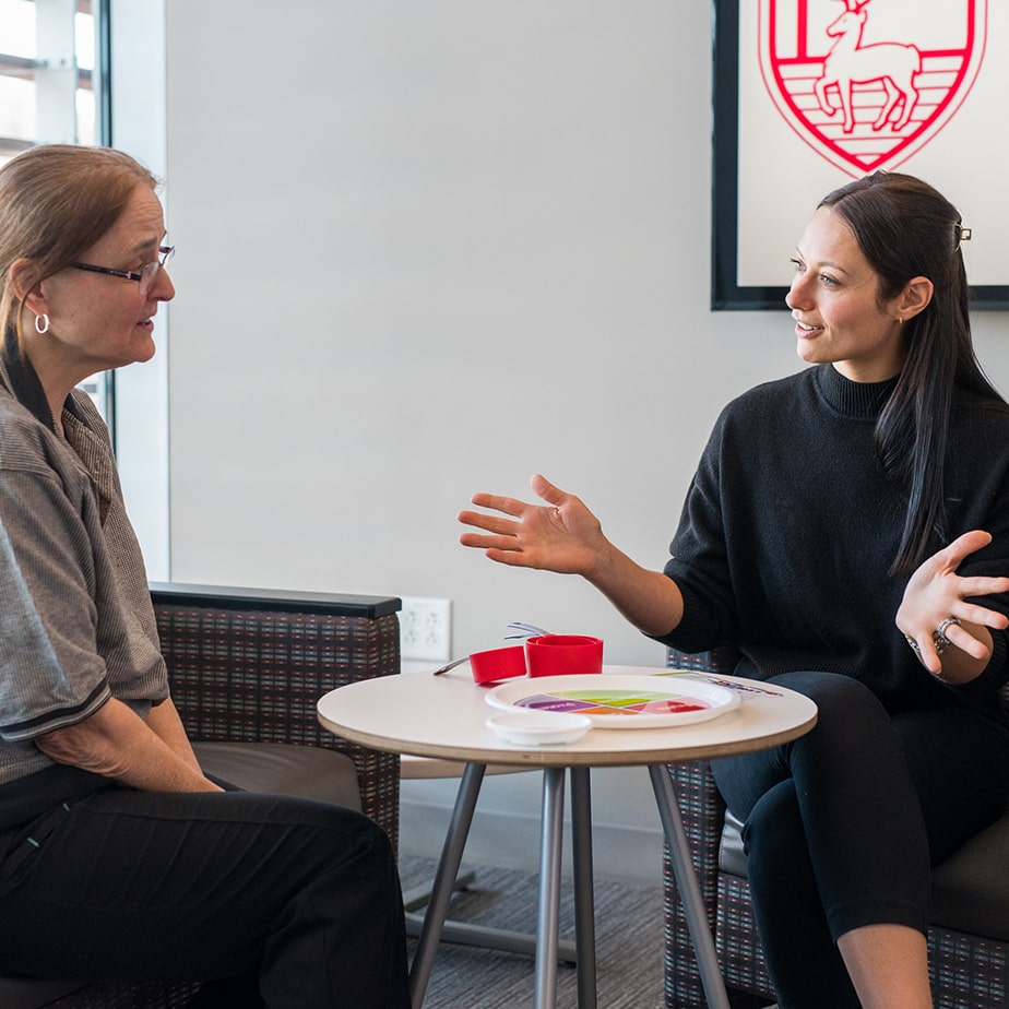 A student and her professor talking at a table.