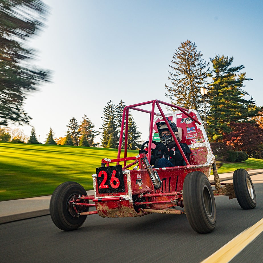 Go kart with Fairfield red colored  frame speeding down a hill. 