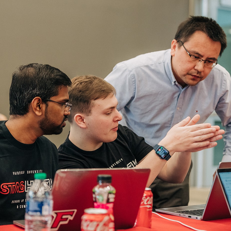 Student explaining something with their hands while professor observes. 