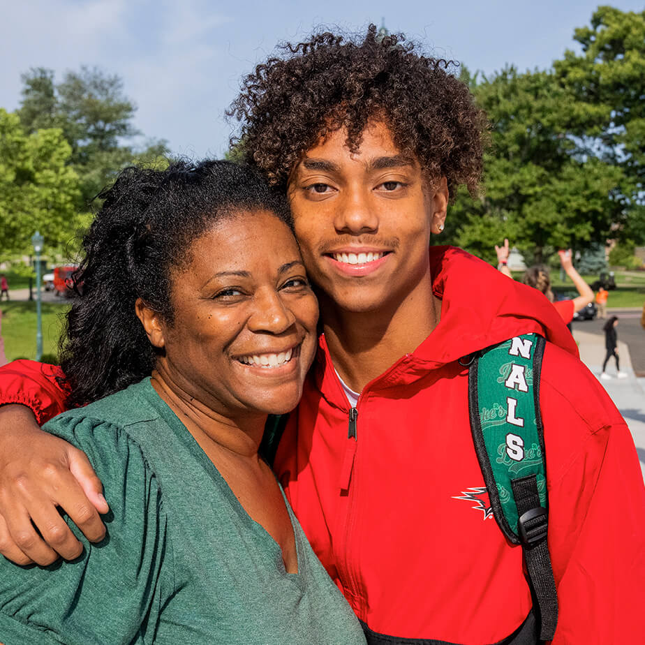 A young student and mother smile together for a joyful photo, showcasing their close bond and affection.