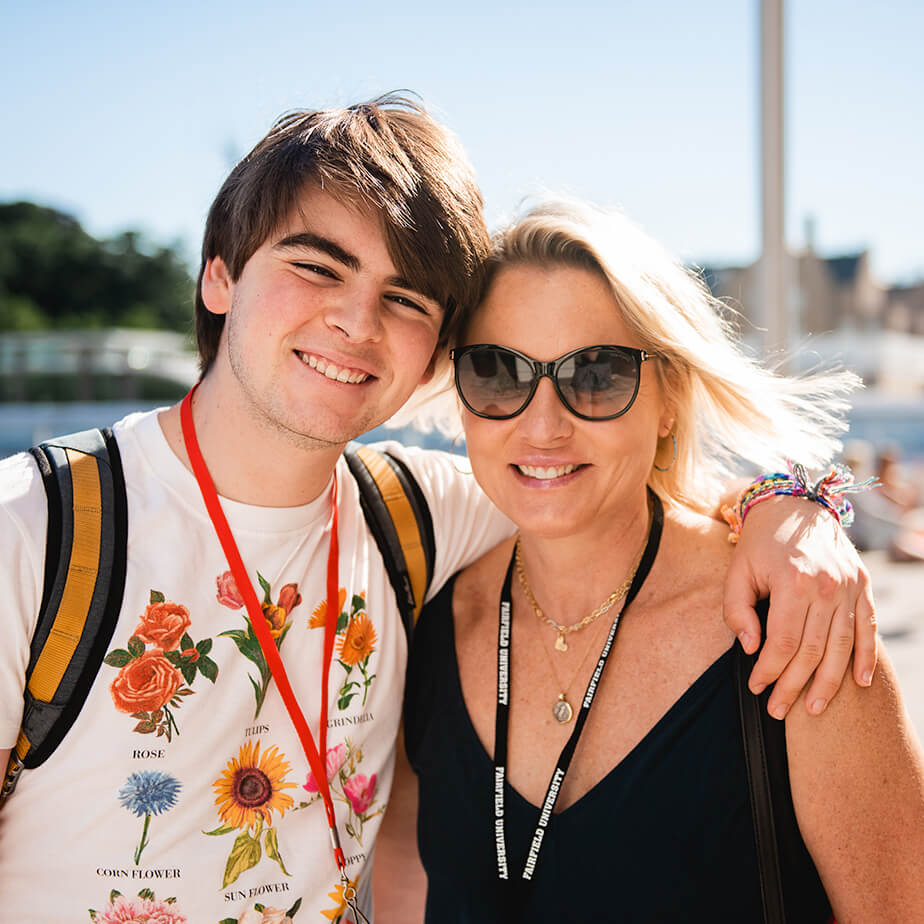 A mother and son pose together for a photo, both displaying joyful expressions.